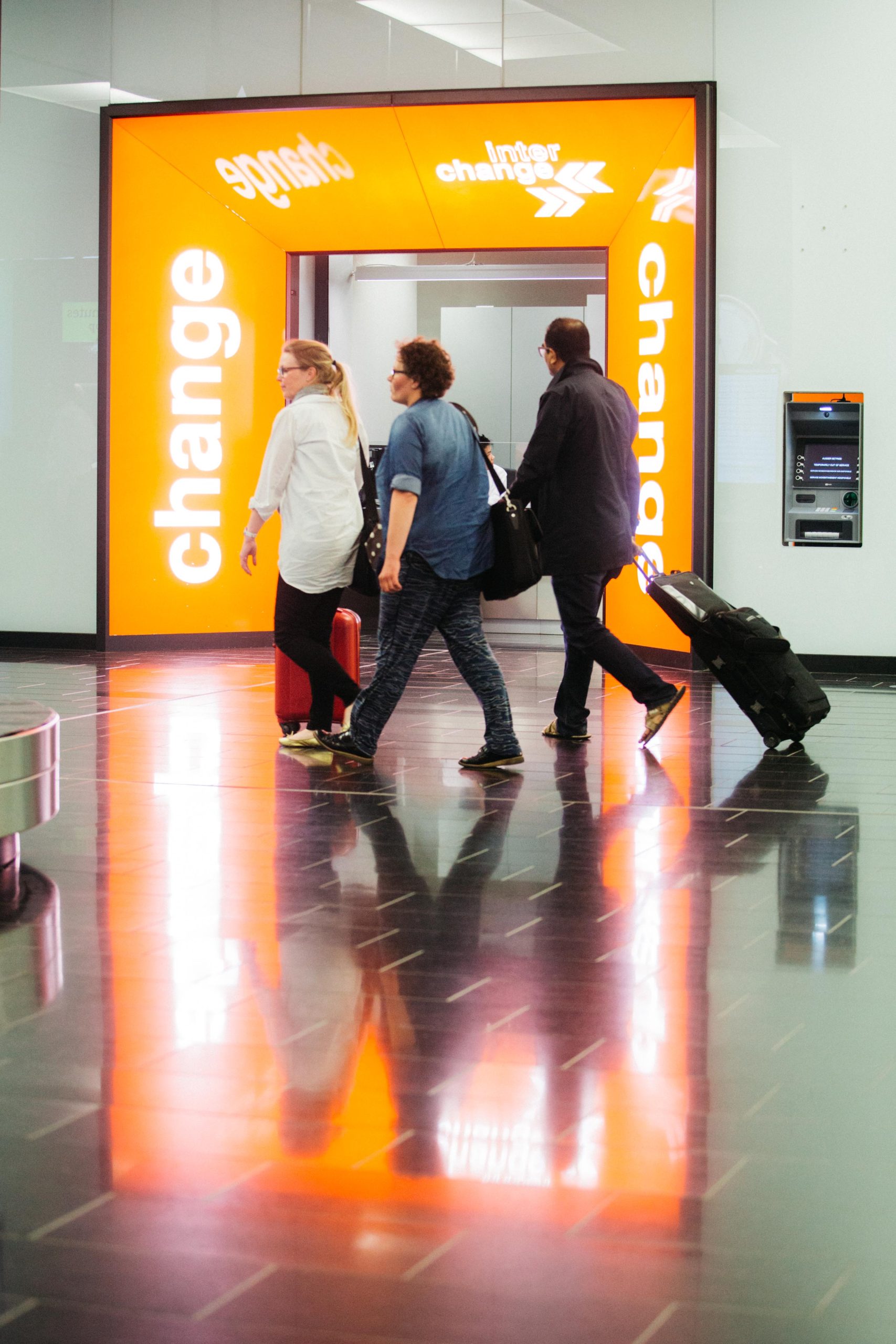 Travellers walking inside the airport with Interchange branch in the background.